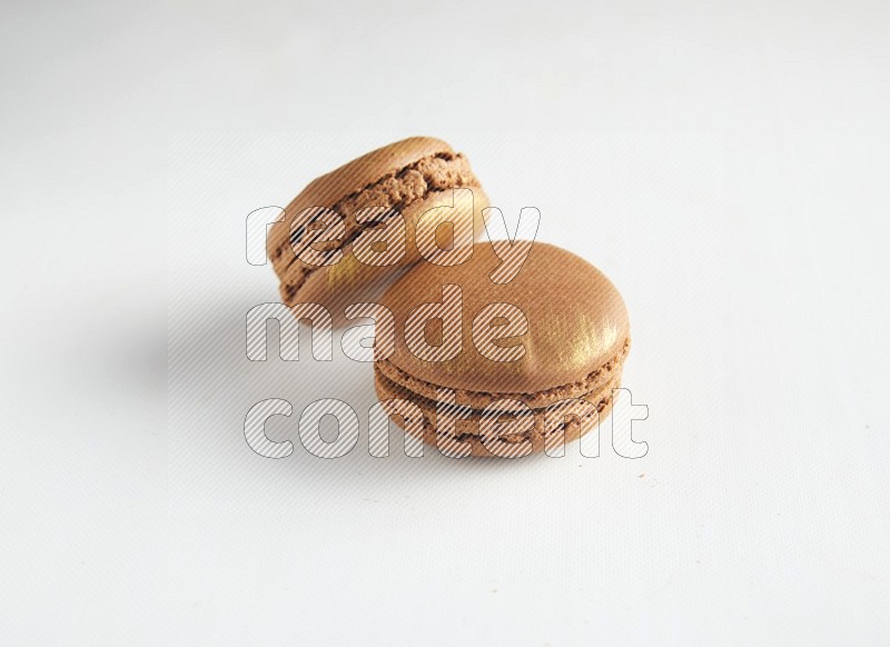 45º Shot of two Brown Coffee macarons on white background