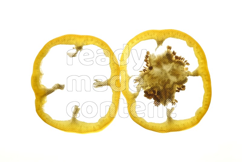 Yellow bell pepper slices on illuminated white background