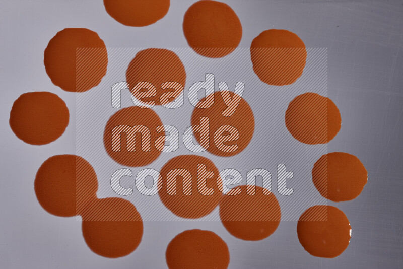 Close-ups of abstract orange paint droplets on the surface