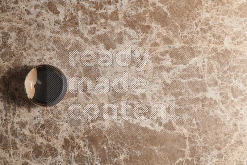 وعاء فخاري متعدد الألوان على خلفية من الرخام البيج