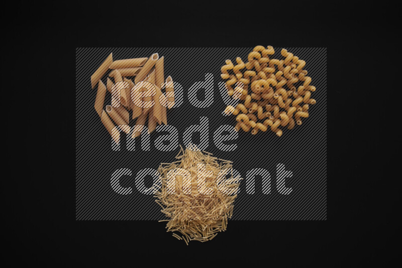 Different pasta types in bunches on black background