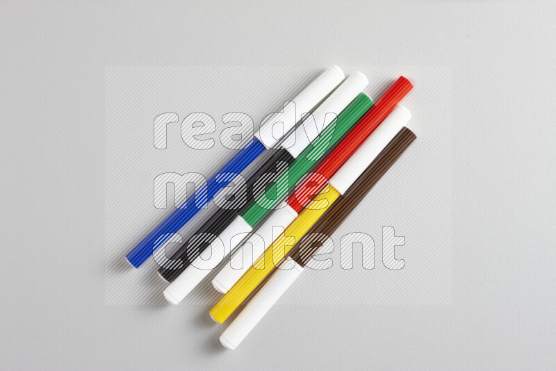 مجموعة من أقلام التلوين بألوان مختلفة علي خلفية رمادية