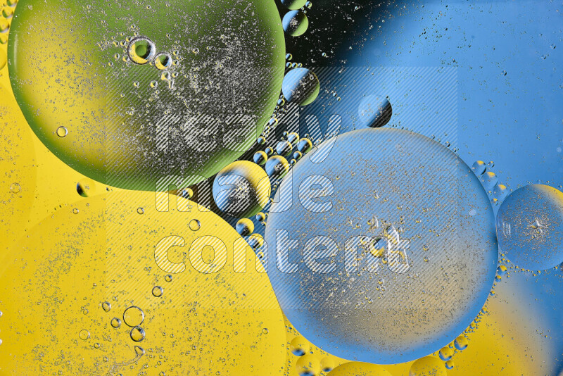 Close-ups of abstract oil bubbles on water surface in shades of yellow, green and blue