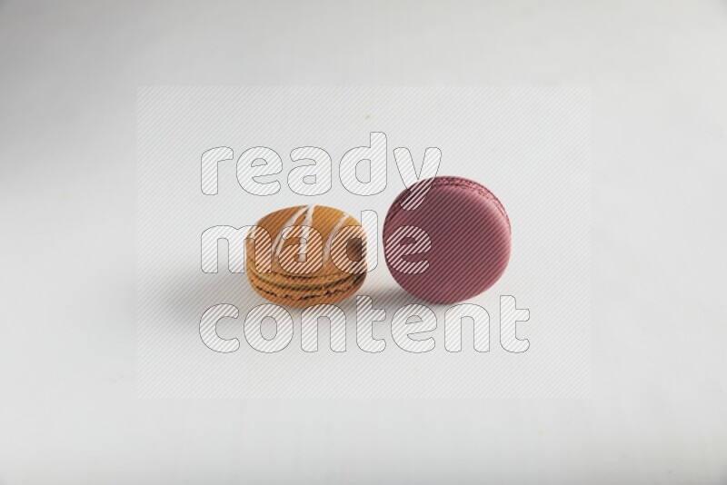 45º Shot of of two assorted Brown Irish Cream, and Red Cherry macarons on white background