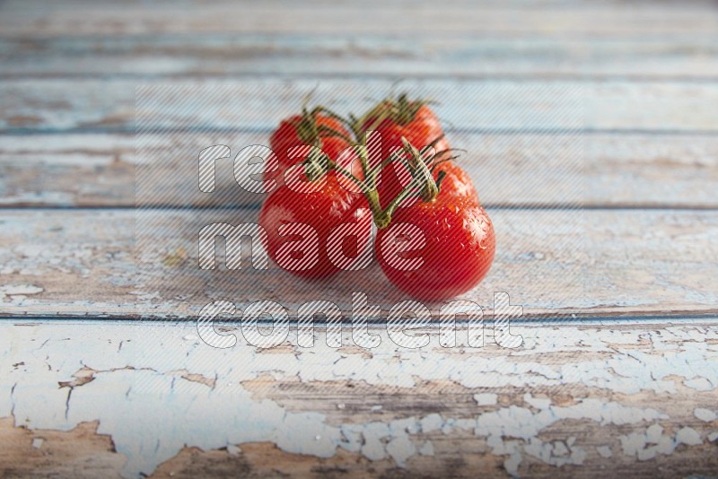 Red cherry tomato vein on a textured blue wooden background 45 degree