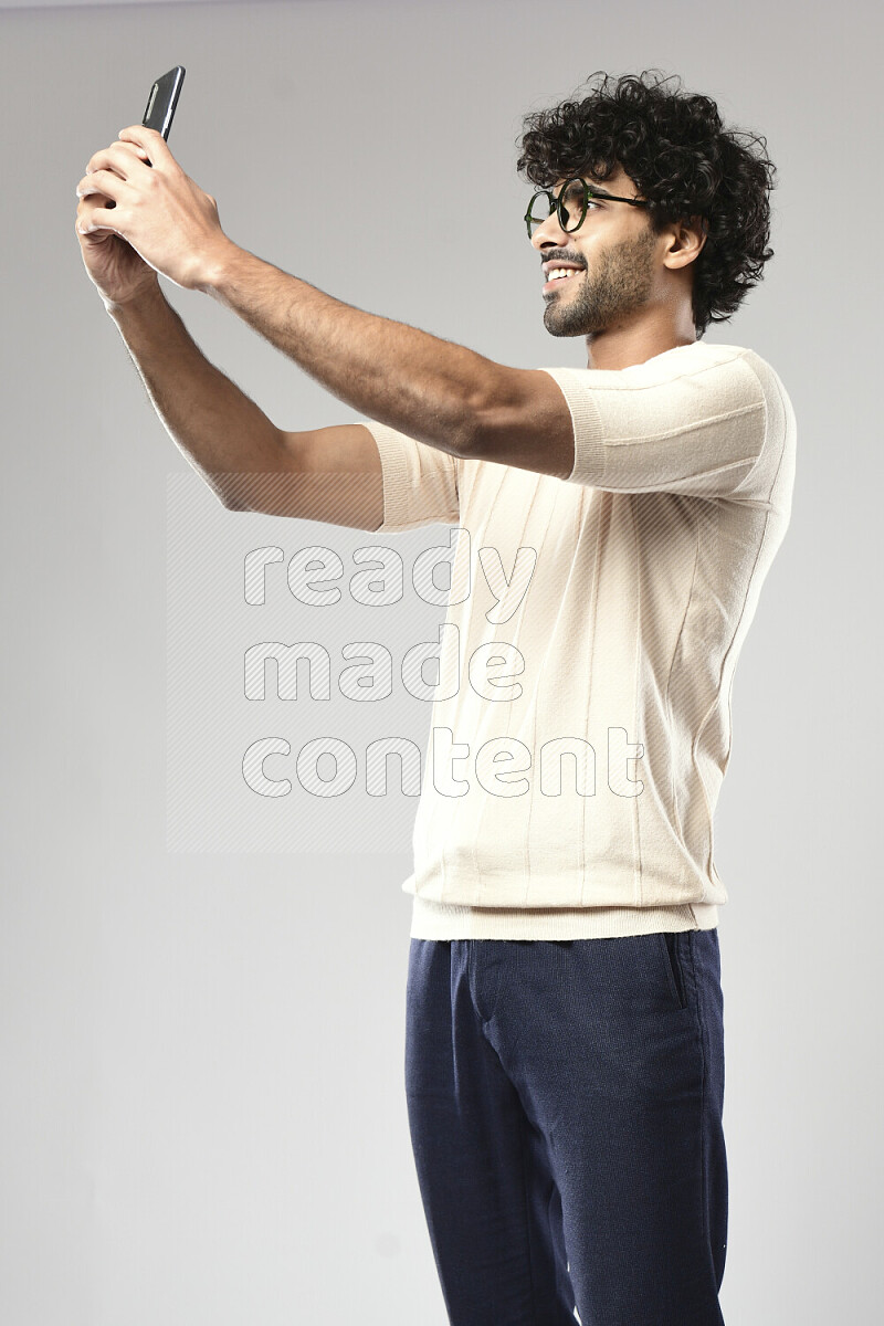رجل يرتدي ملابس كاجوال يلتقط صورة شخصية علي خلفية بيضاء