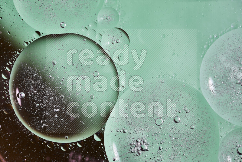 لقطات مقربة لفقاعات من الزيت على سطح الماء باللون الأسود والأخضر