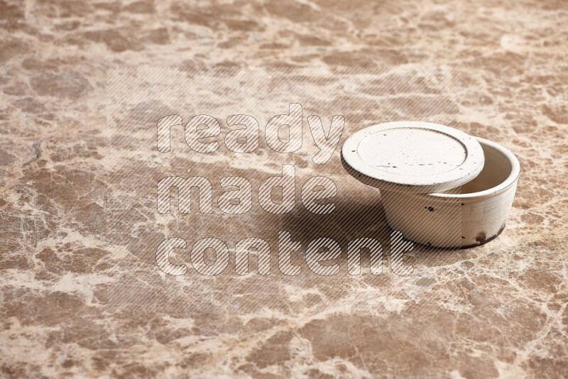 A white pottery bowl on beige marble background