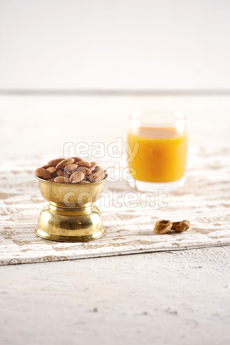 Nuts in a metal bowl with qamar eldin in a light setup