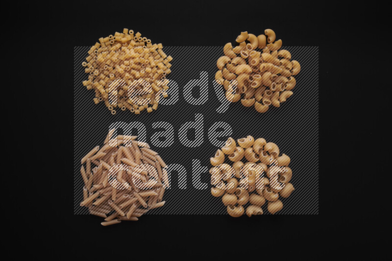 Different pasta types in bunches on black background