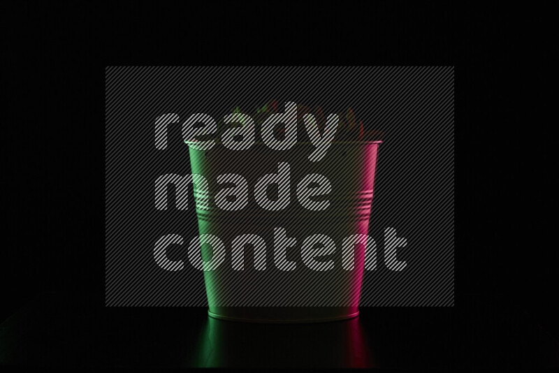 A plant pot with colored rim light against black background