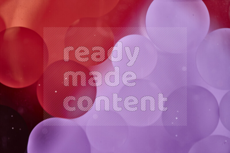 لقطات مقربة لفقاعات من الزيت على سطح الماء باللون الأحمر والوردي