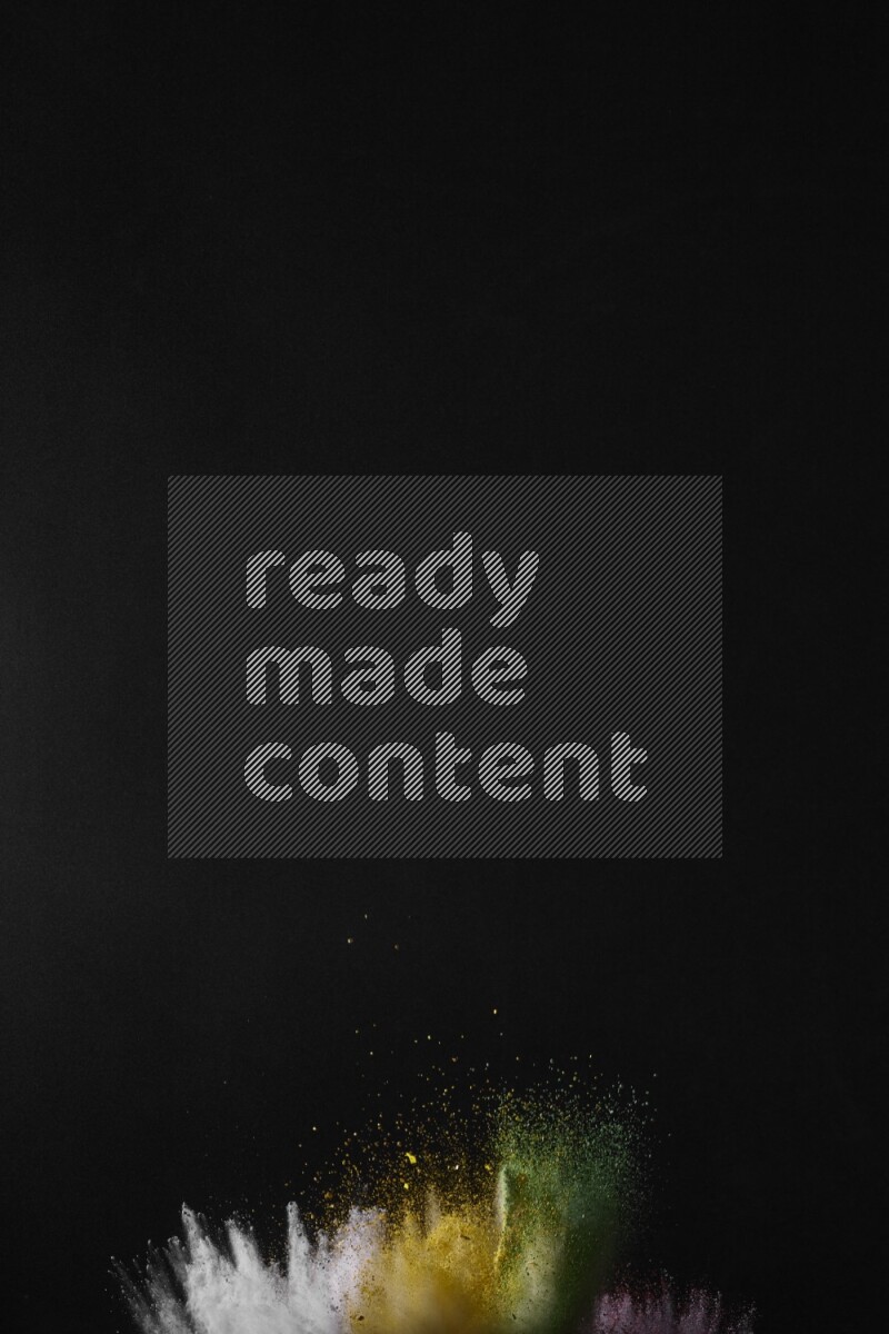 A side view of multicolored powder explosion on black background