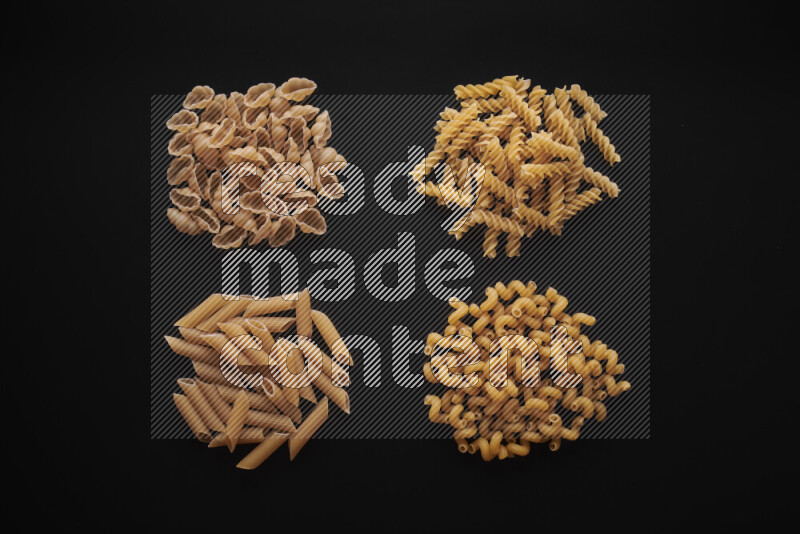Different pasta types in bunches on black background