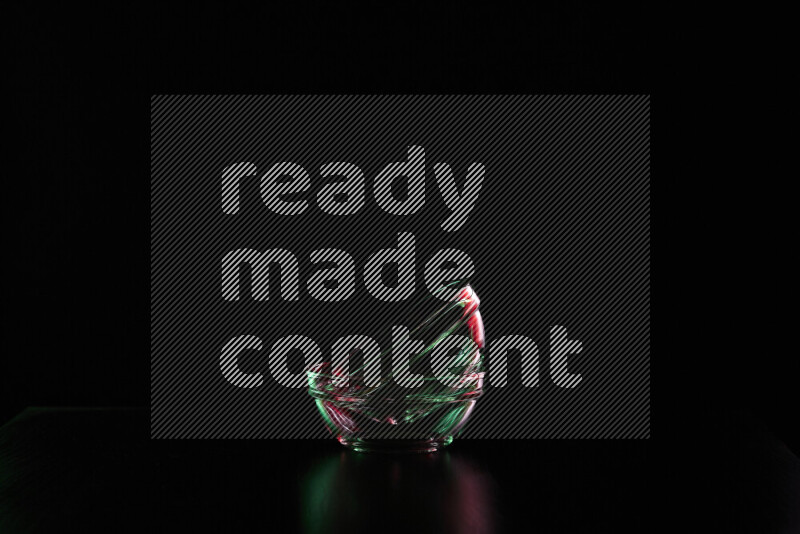 Glassware with rim light in red and green against black background