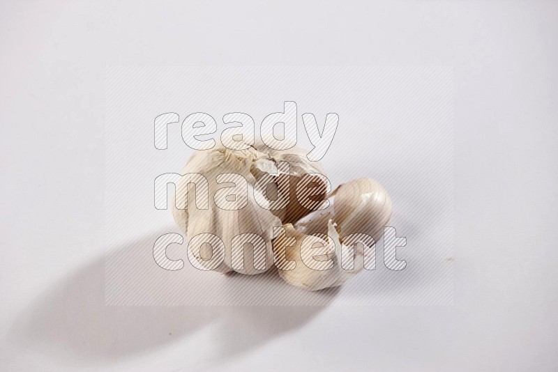 A whole garlic bulb on a white flooring in different angles