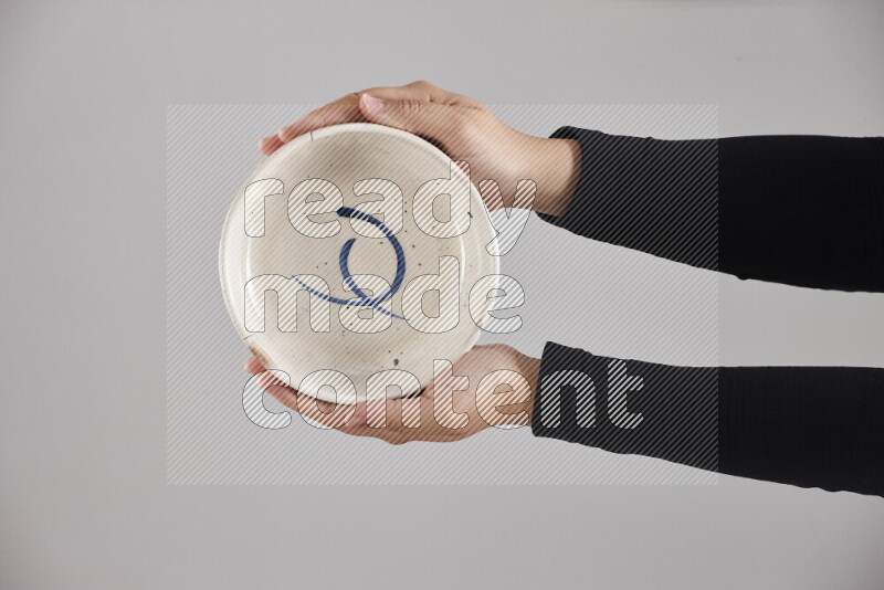 A woman in black abaya holding different pottery essentials in different positions