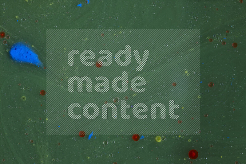 تلتقط الصورة تناثرا للطلاء الأصفر والأحمر والأزرق علي خلفية خضراء