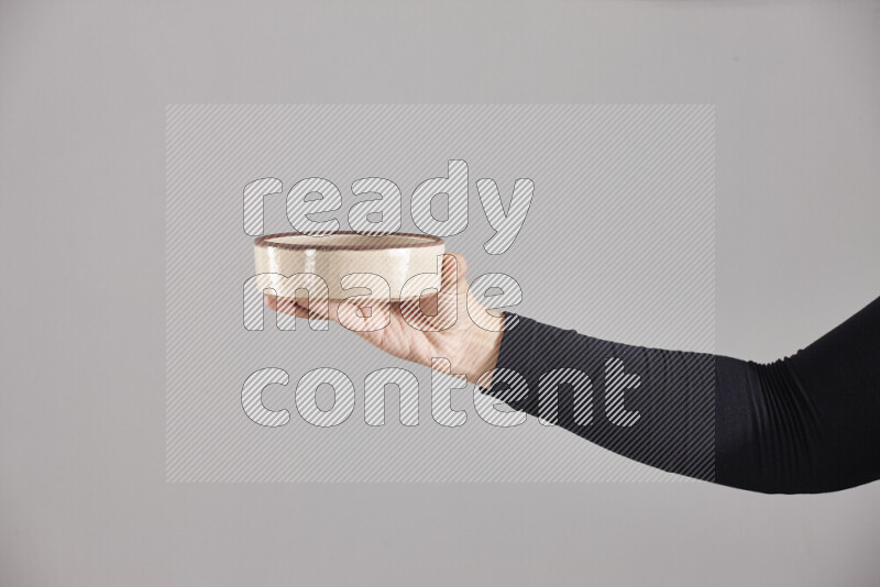A woman in black abaya holding different pottery essentials in different positions