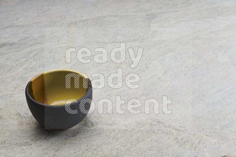 A multicolored pottery bowl on grey marble background