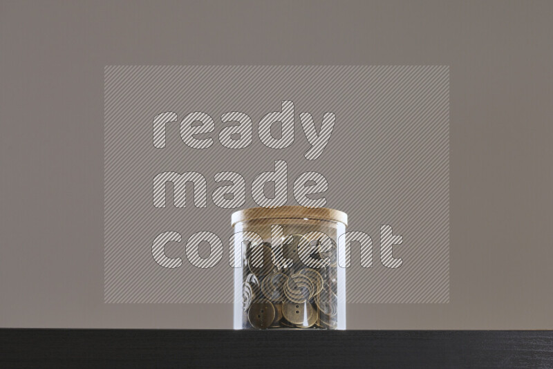 أزرار متنوعة في وعاء زجاجي علي خلفية سوداء