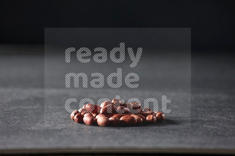 A bunch of red skin peanuts on a black background in different angles