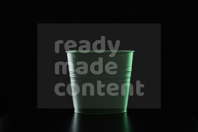 A plant pot with colored rim light against black background