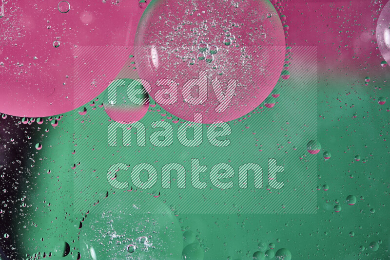 لقطات مقربة لفقاعات من الزيت على سطح الماء باللون الأخضر والوردي