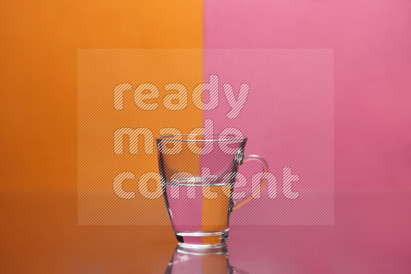 The image features a clear glassware filled with water, set against orange and pink background