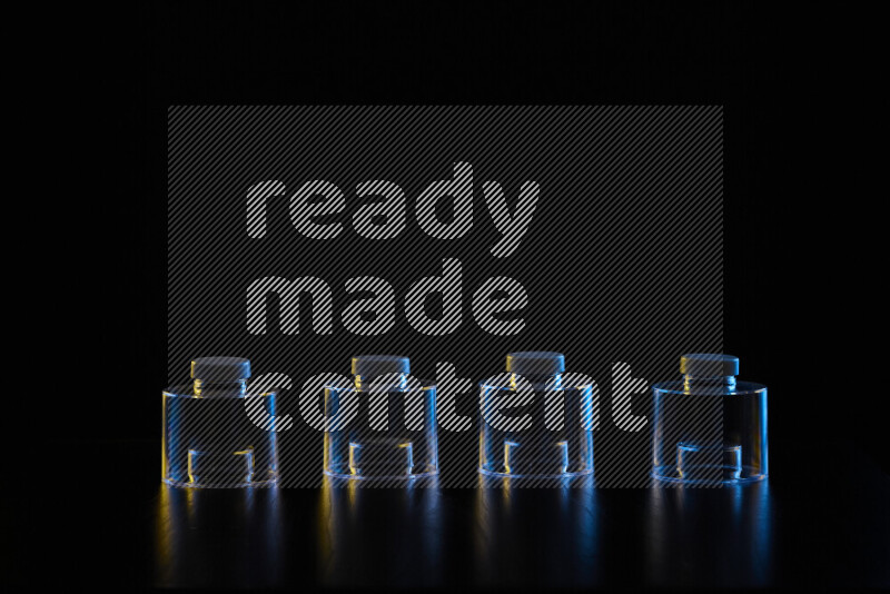 Glassware with rim light in blue and yellow against black background