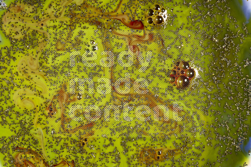 لقطة مقربة لبريق ذهبي متلألئ منتشر على خلفية من اللون الأخضر والأحمر في حركات دائرية