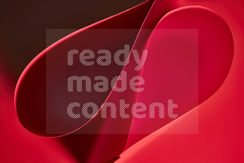 An abstract art of paper folded into smooth curves in red gradients