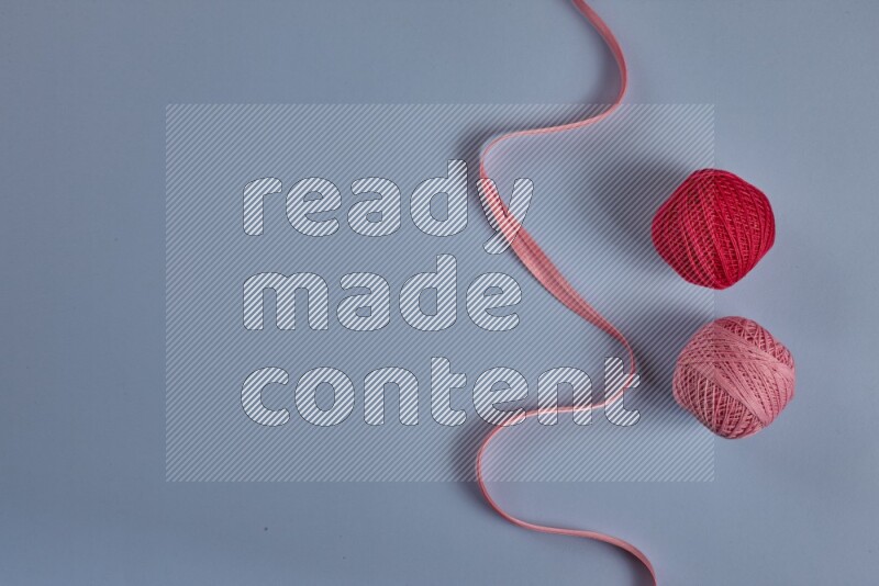 مجموعة من أدوات الخياطة والتفصيل زهرية اللون على خلفية زرقاء