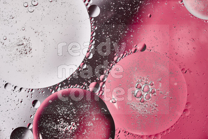 لقطات مقربة لفقاعات من الزيت على سطح الماء باللون الأبيض والوردي
