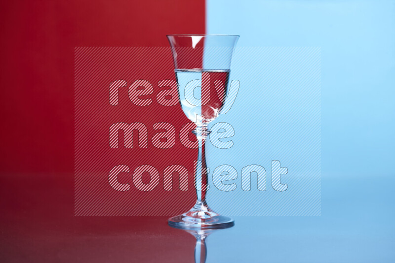 The image features a clear glassware filled with water, set against red and light blue background