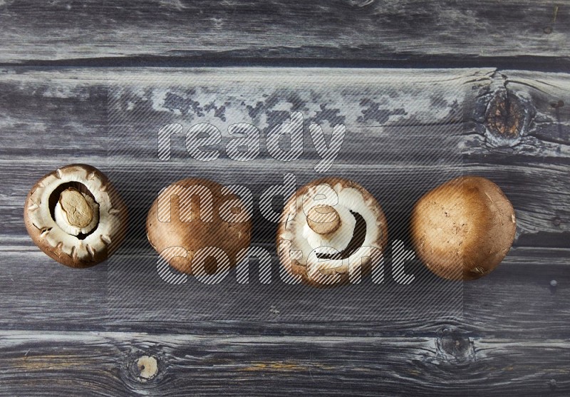 small fresh Cremini wood mushrooms topview on grey wooden textured background