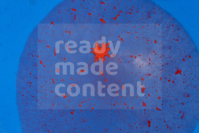 تلتقط الصورة تناثرا للطلاء الأحمر علي خلفية زرقاء