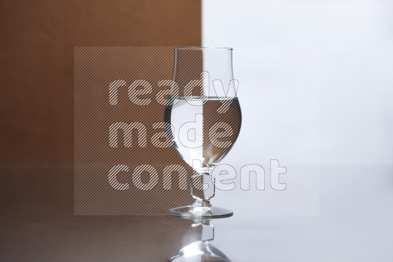 The image features a clear glassware filled with water, set against white and brown background