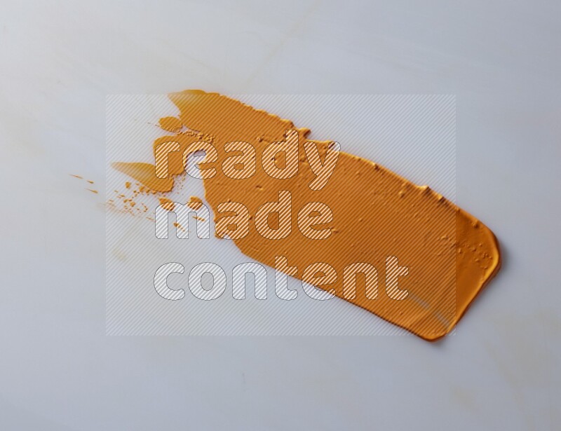 An orange straight painting knife stroke on white background