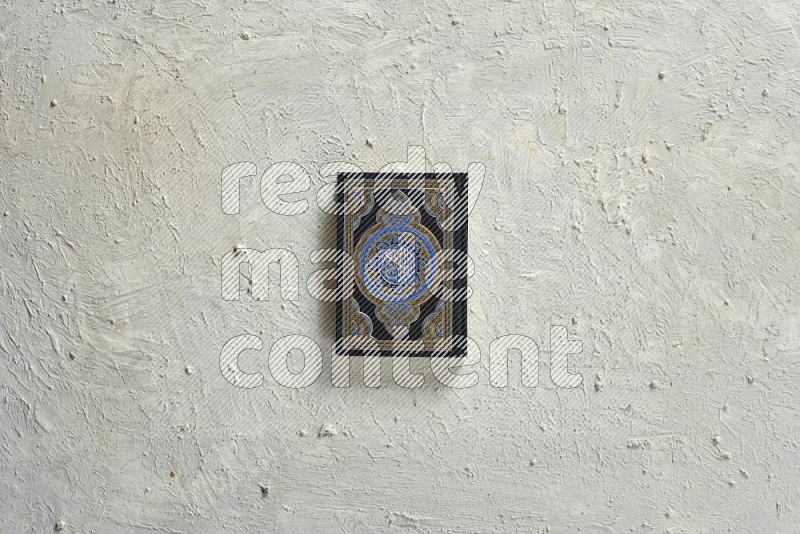 Quran with a prayer beads on textured white background