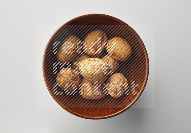 Top-view shot of walnut in a container on white background
