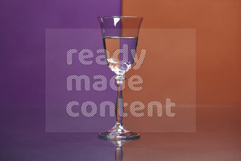 The image features a clear glassware filled with water, set against purple and dark orange background