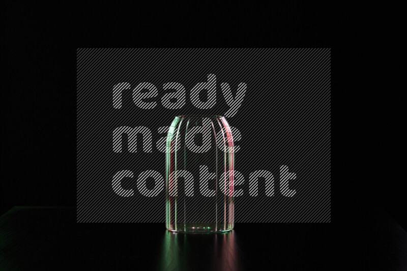 Glassware with rim light in red and green against black background