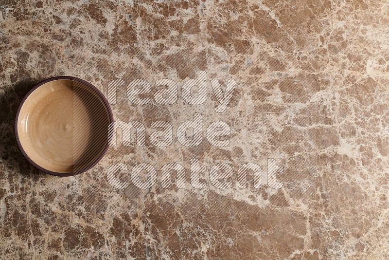 Top View Shot Of A Beige Pottery Oven Plate On beige Marble Flooring