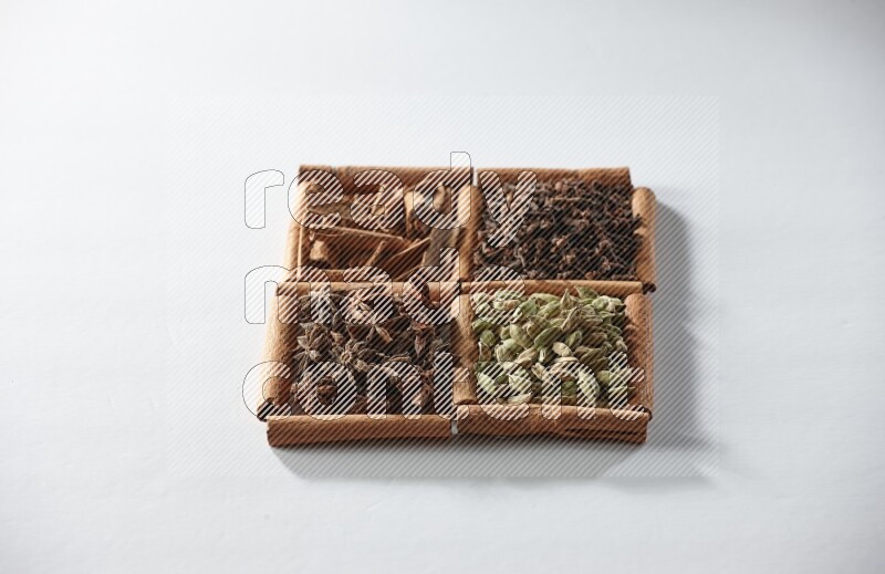 4 squares of cinnamon sticks full of cardamom, star anise, cloves and cinnamon on white flooring