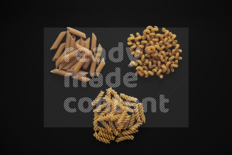 Different pasta types in bunches on black background