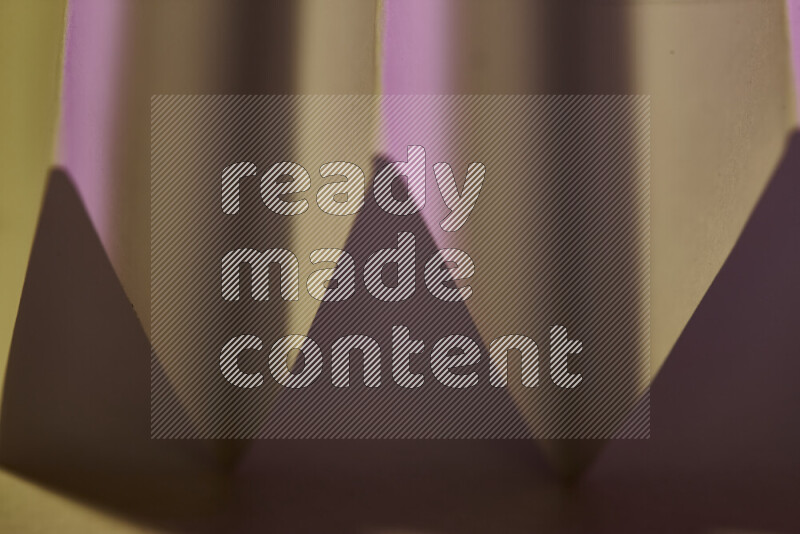 صورة مجردة مقربة تظهر طيات ورقية هندسية حادة بتدرجات اللون الوردي مع درجات لونية دافئة