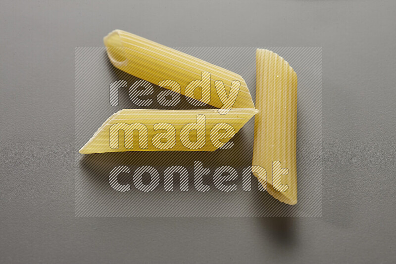 Penne pasta on grey background