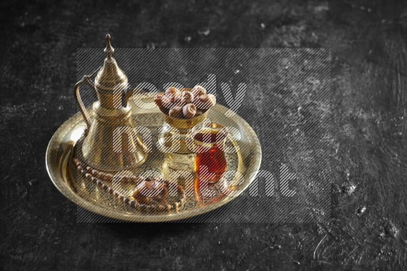 تمر مع مشروب ساخن على صينية معدنية