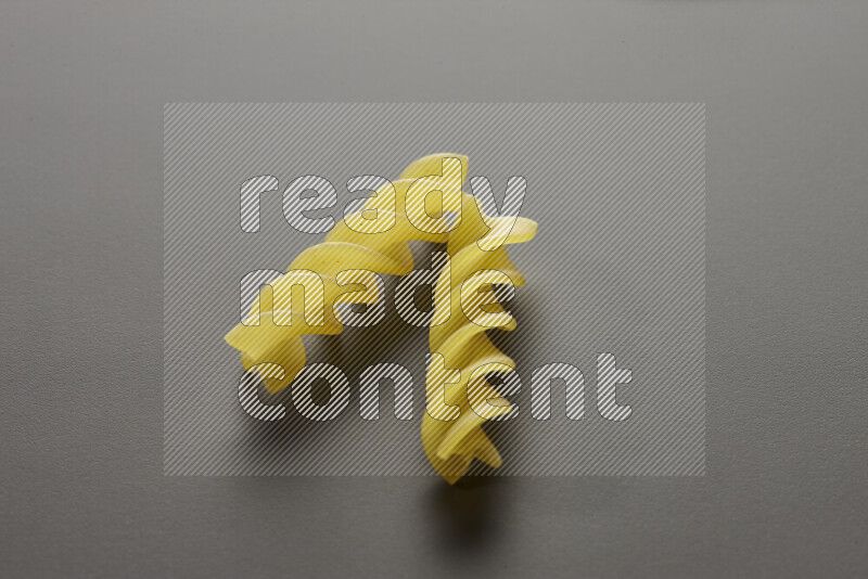 Fusilli pasta on grey background
